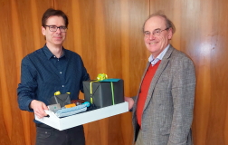 Der Dekan Herr Prof. Dr. Frank Teuteberg überreicht Herrn Prof. Dr. Rieger ein Geschenk zum Abschied.